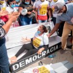 Mujer se “tira” a un ataúd en protesta frente al Palacio Nacional