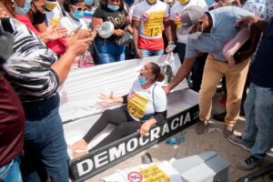 Mujer se “tira” a un ataúd en protesta frente al Palacio Nacional